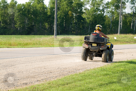 To use this stock image in your creative project, please select the size you need over to the right and click the "Add to Cart" button.
Your downloaded image will come with the Cutcaster watermark removed so don’t worry about the watermark you see on this page. ATV stock photo, An ATV driving away down the side of a road with copyspace behind by Richard Nelson