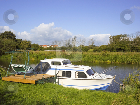 To use this stock image in your creative project, please select the size you need over to the right and click the "Add to Cart" button.
Your downloaded image will come with the Cutcaster watermark removed so don’t worry about the watermark you see on this page. Pleasure boat stock photo, A sailing boat moored by a river bank in summer by Mike Smith