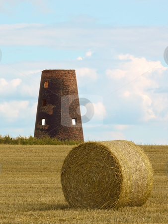 To use this stock image in your creative project, please select the size you need over to the right and click the "Add to Cart" button.
Your downloaded image will come with the Cutcaster watermark removed so don’t worry about the watermark you see on this page. Old windmill stock photo, An old windmill in afield of round bales at harvest time in summer by Mike Smith