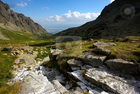 To use this stock image in your creative project, please select the size you need over to the right and click the "Add to Cart" button.
Your downloaded image will come with the Cutcaster watermark removed so don’t worry about the watermark you see on this page. Stones in a mountain valley stock photo, Stones in a mountain valley with a lake on horizon by Juraj Kovacik