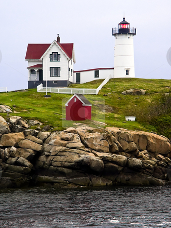 To use this stock image in your creative project, please select the size you need over to the right and click the "Add to Cart" button.
Your downloaded image will come with the Cutcaster watermark removed so don’t worry about the watermark you see on this page. Nubble Light, Cape Neddick, Maine stock photo, The Nubble Light shines its red light at dusk on an overcast evening at Cape Neddick, Maine. by Kenneth Keifer