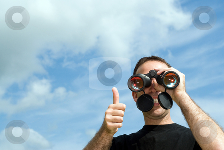 To use this stock image in your creative project, please select the size you need over to the right and click the "Add to Cart" button.
Your downloaded image will come with the Cutcaster watermark removed so don’t worry about the watermark you see on this page. Thumbs Up stock photo, A young man gives a thumbs up as he holds a set of binoculars to his eyes, with clouds and blue sky behind him by Richard Nelson