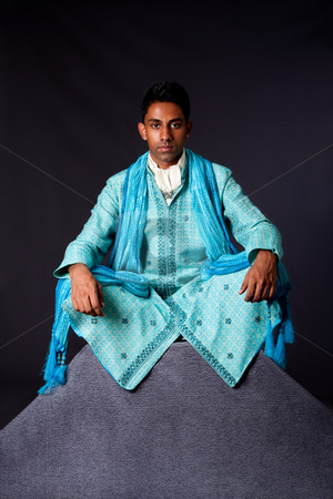 To use this stock image in your creative project, please select the size you need over to the right and click the "Add to Cart" button.
Your downloaded image will come with the Cutcaster watermark removed so don’t worry about the watermark you see on this page. Hindu man sitting in lotus position stock photo, Beautiful authentic Indian hindu man in typical ethnic groom attire sitting in lotus position with legs crossed on top of rock. Bangali male wearing a light blue agua decorated Dhoti with shawl. by Paul Hakimata
