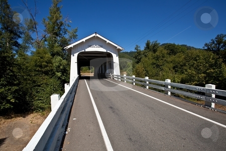 To use this stock image in your creative project, please select the size you need over to the right and click the "Add to Cart" button.
Your downloaded image will come with the Cutcaster watermark removed so don’t worry about the watermark you see on this page. Grave Creek Bridge stock photo, Grave Creek covered span at Sunny Valley, about 15 miles north of Grants Pass, can be seen by motorists traveling Interstate 5. by Mariusz Jurgielewicz
