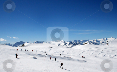 To use this stock image in your creative project, please select the size you need over to the right and click the "Add to Cart" button.
Your downloaded image will come with the Cutcaster watermark removed so don’t worry about the watermark you see on this page. Skiers on mountainside stock photo, Skiers on snowy mountainside under blue sky, Switzerland. by Martin Crowdy