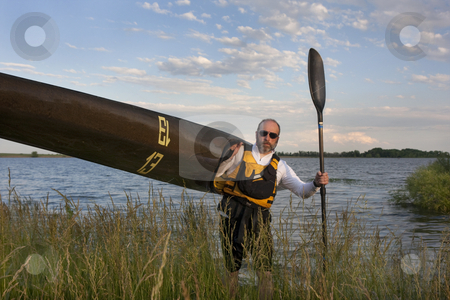 To use this stock image in your creative project, please select the size you need over to the right and click the "Add to Cart" button.
Your downloaded image will come with the Cutcaster watermark removed so don’t worry about the watermark you see on this page. Paddler carrying a racing kayak with number thirteen stock photo, Mature paddler carrying his long racing kayak on a grassy lake shore in northern Colorado, thirteen - temporary race number placed on deck by myself by Marek Uliasz