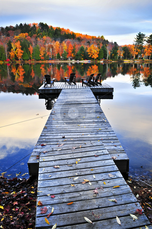 To use this stock image in your creative project, please select the size you need over to the right and click the "Add to Cart" button.
Your downloaded image will come with the Cutcaster watermark removed so don’t worry about the watermark you see on this page. Wooden dock on autumn lake stock photo, Wooden dock with chairs on calm fall lake by Elena Elisseeva