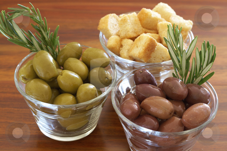 To use this stock image in your creative project, please select the size you need over to the right and click the "Add to Cart" button.
Your downloaded image will come with the Cutcaster watermark removed so don’t worry about the watermark you see on this page. Two jars of green and black olives and croutons stock photo, Two jars of green and black olives with stick of rosemary and croutons on wooden table background by Elena Weber (nee Talberg)