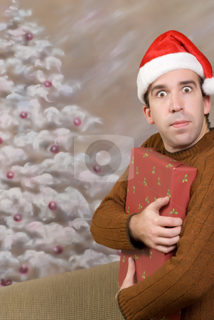 To use this stock image in your creative project, please select the size you need over to the right and click the "Add to Cart" button.
Your downloaded image will come with the Cutcaster watermark removed so don’t worry about the watermark you see on this page. Greed stock photo, A young man is being greedy and holding a Christmas present close to his chest by Richard Nelson