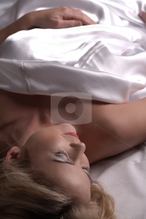 To use this stock image in your creative project, please select the size you need over to the right and click the "Add to Cart" button.
Your downloaded image will come with the Cutcaster watermark removed so don’t worry about the watermark you see on this page. Nude adult woman stock photo, Sensual naked young blonde adult Caucasian woman, wrapped in a satin, silk sheet on a bed in her bedroom. High contrast lighting. by Sean Nel