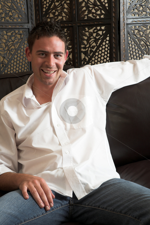 To use this stock image in your creative project, please select the size you need over to the right and click the "Add to Cart" button.
Your downloaded image will come with the Cutcaster watermark removed so don’t worry about the watermark you see on this page. Relaxed young man stock photo, Relaxed young adult male wearing blue jeans, a loose white cotton shirt and sitting comfortable on a leather couch by Sean Nel