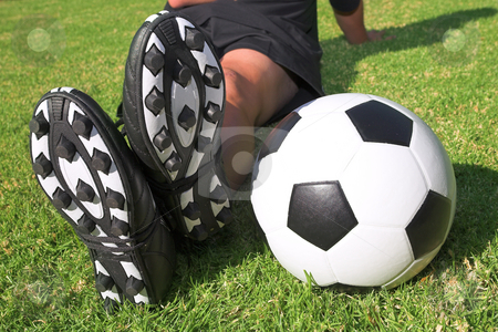 To use this stock image in your creative project, please select the size you need over to the right and click the "Add to Cart" button.
Your downloaded image will come with the Cutcaster watermark removed so don’t worry about the watermark you see on this page. Football player with a soccer ball on soccer pitch stock photo, A male soccer (football) player, referee or coach sitting next to a soccer ball. The image is of feet and legs, with soccer togs, and a black and white ball. Focus on soccer ball and heels by Sean Nel