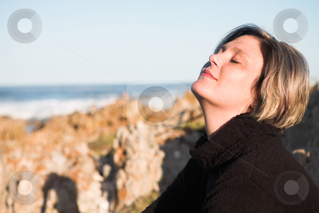 To use this stock image in your creative project, please select the size you need over to the right and click the "Add to Cart" button.
Your downloaded image will come with the Cutcaster watermark removed so don’t worry about the watermark you see on this page. Beautiful adult woman sitting on the beach stock photo, Beautiful adult woman with short hair sitting on the beach in the last rays of the setting sun, smiling and looking up. Coastal rocks and the ocean in the background by Sean Nel