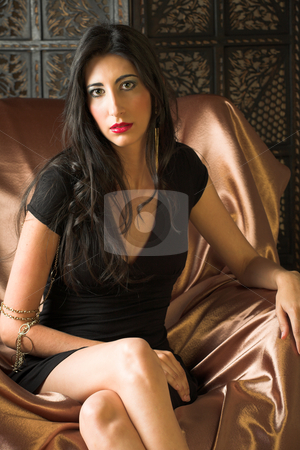 To use this stock image in your creative project, please select the size you need over to the right and click the "Add to Cart" button.
Your downloaded image will come with the Cutcaster watermark removed so don’t worry about the watermark you see on this page. Italian adult woman stock photo, Beautiful young sexy adult Italian woman with long black hair, in formal black dress on a textured wooden background, sitting on a luxurious couch ? Hard light, high key by Sean Nel