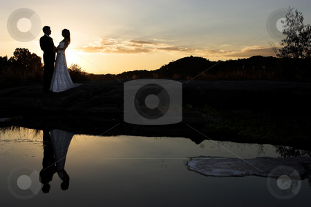 To use this stock image in your creative project, please select the size you need over to the right and click the "Add to Cart" button.
Your downloaded image will come with the Cutcaster watermark removed so don’t worry about the watermark you see on this page. Sunset bride stock photo, Bride and groom next to river at sunset by Sean Nel