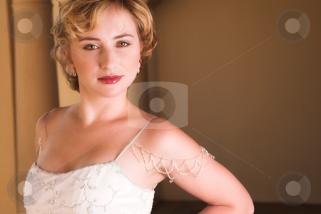 To use this stock image in your creative project, please select the size you need over to the right and click the "Add to Cart" button.
Your downloaded image will come with the Cutcaster watermark removed so don’t worry about the watermark you see on this page. Young blonde bride wearing wedding gown stock photo, Young blonde bride with champagne colored wedding gown and red lips. She is looking over her shoulder with an alluring and seductive look in her green eyes. She is in a luxurious bedroom by Sean Nel