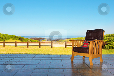 To use this stock image in your creative project, please select the size you need over to the right and click the "Add to Cart" button.
Your downloaded image will come with the Cutcaster watermark removed so don’t worry about the watermark you see on this page. Comfortable chair on patio at seaside stock photo, A comfortable leather chair on a patio at a seaside residence or holiday home by Sean Nel