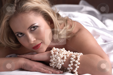 To use this stock image in your creative project, please select the size you need over to the right and click the "Add to Cart" button.
Your downloaded image will come with the Cutcaster watermark removed so don’t worry about the watermark you see on this page. Nude adult woman stock photo, Sensual naked young blonde adult Caucasian woman, wrapped in a satin, silk sheet on a bed in her bedroom. High contrast lighting. by Sean Nel