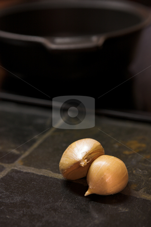 To use this stock image in your creative project, please select the size you need over to the right and click the "Add to Cart" button.
Your downloaded image will come with the Cutcaster watermark removed so don’t worry about the watermark you see on this page. Cloves of garlic lying on a kitchen counter stock photo, Two cloves of garlic lying on a black stone kitchen counter with a steel pot in the background by Sean Nel