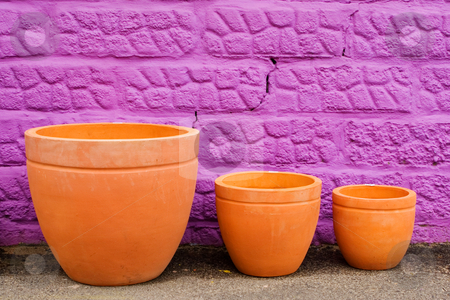 To use this stock image in your creative project, please select the size you need over to the right and click the "Add to Cart" button.
Your downloaded image will come with the Cutcaster watermark removed so don’t worry about the watermark you see on this page. Pots #2 stock photo, Colourful pots on gravelroad next to purple wall by Sean Nel