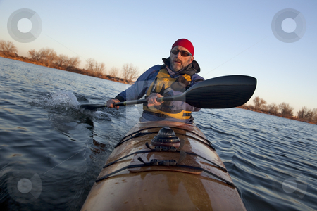 To use this stock image in your creative project, please select the size you need over to the right and click the "Add to Cart" button.
Your downloaded image will come with the Cutcaster watermark removed so don’t worry about the watermark you see on this page. Paddling workout in a sea kayak stock photo, Mature male paddler exercising (turning boat using rudder stroke with his wing carbon fiber paddle) in a home built wooden sea kayak on lake, fall scenery in Colorado, view from kayak bow by Marek Uliasz