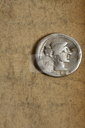 To use this stock image in your creative project, please select the size you need over to the right and click the "Add to Cart" button.
Your downloaded image will come with the Cutcaster watermark removed so don’t worry about the watermark you see on this page. Ancient silver denauius coin on paper stock photo, Silver AR denarius from Roman Republic dated 89bc on aged paper. Front side depicting female draped hair taken in chignon. Behind the nape of the neck, ROMA, Under the neck, M.Cato. Issuance of coinage was administered by annuallly elected magistrates (moneyers) and coins usually bear their names. Space for text. by Leah-Anne Thompson