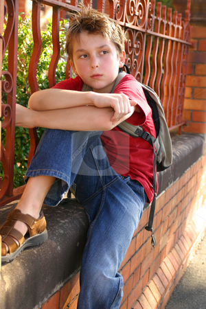 To use this stock image in your creative project, please select the size you need over to the right and click the "Add to Cart" button.
Your downloaded image will come with the Cutcaster watermark removed so don’t worry about the watermark you see on this page. Boy with schoolbag slung over shoulder stock photo, Child sitting on the edge of a brick and wrought iron wall. by Leah-Anne Thompson