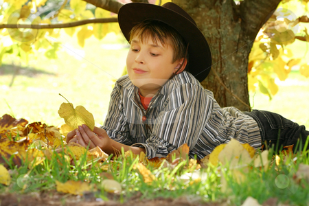 To use this stock image in your creative project, please select the size you need over to the right and click the "Add to Cart" button.
Your downloaded image will come with the Cutcaster watermark removed so don’t worry about the watermark you see on this page. Child holding autumn leaves stock photo, A child resting under a deciduous tree and playing with fallen autumn leaves. The process of leaves changing colour is called photoperiodism, the ability of plants to measure length of light and adjust accordingly - please note 400iso f7 by Leah-Anne Thompson