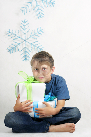 To use this stock image in your creative project, please select the size you need over to the right and click the "Add to Cart" button.
Your downloaded image will come with the Cutcaster watermark removed so don’t worry about the watermark you see on this page. Boy holding Christmas Presents stock photo, A sitting child holding Christmas gifts tied with bright ribbon. by Leah-Anne Thompson