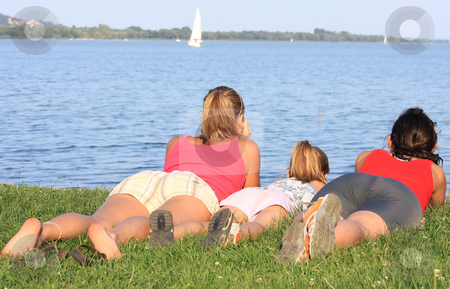 To use this stock image in your creative project, please select the size you need over to the right and click the "Add to Cart" button.
Your downloaded image will come with the Cutcaster watermark removed so don’t worry about the watermark you see on this page. Family stock photo, Three joyful girls are lying prone on the shore by ARPAD RADOCZY