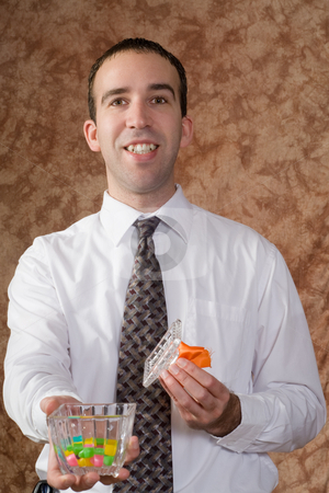 To use this stock image in your creative project, please select the size you need over to the right and click the "Add to Cart" button.
Your downloaded image will come with the Cutcaster watermark removed so don’t worry about the watermark you see on this page. Businessman Offering Candy stock photo, A young businessman offering some candy from a glass dish by Richard Nelson