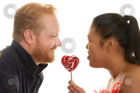 To use this stock image in your creative project, please select the size you need over to the right and click the "Add to Cart" button.
Your downloaded image will come with the Cutcaster watermark removed so don’t worry about the watermark you see on this page. Two people share a candy stock photo, Diversity couple facing each other with a red and white candy. Focus to lollipop by Leah-Anne Thompson