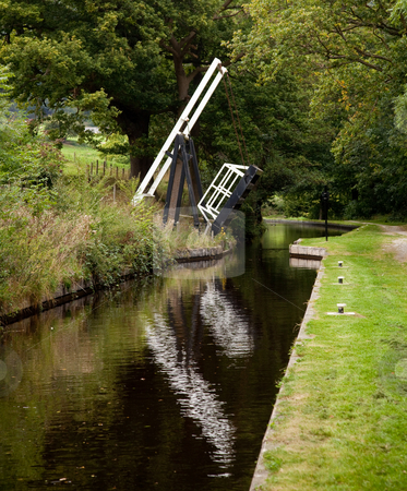 To use this stock image in your creative project, please select the size you need over to the right and click the "Add to Cart" button.
Your downloaded image will come with the Cutcaster watermark removed so don’t worry about the watermark you see on this page. Open bridge over still canal stock photo, Canal in England with a bridge open to boat traffic by Steven Heap