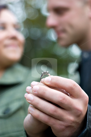 To use this stock image in your creative project, please select the size you need over to the right and click the "Add to Cart" button.
Your downloaded image will come with the Cutcaster watermark removed so don’t worry about the watermark you see on this page. Young Engaged Couple stock photo, A young happy couple holding a diamond engagement ring. Shallow depth of field with focus on the ring. by Todd Arena