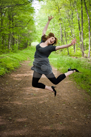 To use this stock image in your creative project, please select the size you need over to the right and click the "Add to Cart" button.
Your downloaded image will come with the Cutcaster watermark removed so don’t worry about the watermark you see on this page. Joyful Jumping Woman stock photo, A young woman joyously jumping in the air in a wooded setting. by Todd Arena