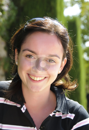 To use this stock image in your creative project, please select the size you need over to the right and click the "Add to Cart" button.
Your downloaded image will come with the Cutcaster watermark removed so don’t worry about the watermark you see on this page. Young girl smiling stock photo, Young teenage girl with brown hair and brown eyes smiling and wearing sunglasses on her head and a black shirt with white and pink stripes. Photo taken on the 2nd of October, 2009. by Alessandro Rizzolli