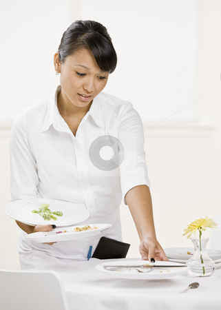 To use this stock image in your creative project, please select the size you need over to the right and click the "Add to Cart" button.
Your downloaded image will come with the Cutcaster watermark removed so don’t worry about the watermark you see on this page. Female Server stock photo, Young female server clearing table. Vertically framed shot. by Jonathan Ross