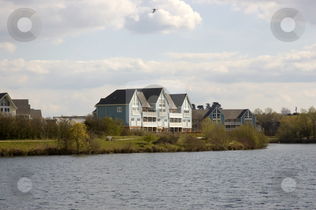 To use this stock image in your creative project, please select the size you need over to the right and click the "Add to Cart" button.
Your downloaded image will come with the Cutcaster watermark removed so don’t worry about the watermark you see on this page. Lake houses stock photo, A lake with some wooden clad homes by Mark Bond