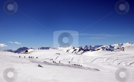 To use this stock image in your creative project, please select the size you need over to the right and click the "Add to Cart" button.
Your downloaded image will come with the Cutcaster watermark removed so don’t worry about the watermark you see on this page. Skiers on mountainside stock photo, Skiers on snowy mountainside under blue sky, Switzerland. by Martin Crowdy