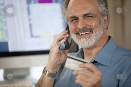 To use this stock image in your creative project, please select the size you need over to the right and click the "Add to Cart" button.
Your downloaded image will come with the Cutcaster watermark removed so don’t worry about the watermark you see on this page. Businessman Paying Over Phone With Credit Card stock photo, A businessman holding up a credit card and making a payment on his cellphone with a computer monitor in the background. Horizontal shot. by Edward Bock