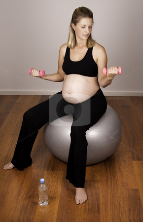 To use this stock image in your creative project, please select the size you need over to the right and click the "Add to Cart" button.
Your downloaded image will come with the Cutcaster watermark removed so don’t worry about the watermark you see on this page. Healthy Pregnancy stock photo, Pregnant woman excercising with weights on an excercise ball by Jandrie Lombard