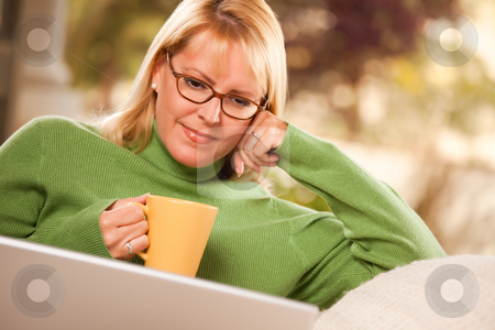 To use this stock image in your creative project, please select the size you need over to the right and click the "Add to Cart" button.
Your downloaded image will come with the Cutcaster watermark removed so don’t worry about the watermark you see on this page. Beautiful Woman Enjoys Her Warm Drink and Laptop stock photo, Beautiful, Smiling Woman Enjoys Her Warm Drink and Laptop Relaxing Day. by Andy Dean