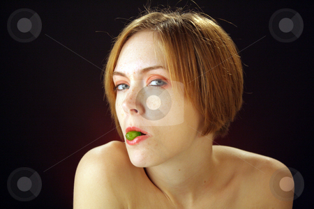 To use this stock image in your creative project, please select the size you need over to the right and click the "Add to Cart" button.
Your downloaded image will come with the Cutcaster watermark removed so don’t worry about the watermark you see on this page. Beautiful Young Woman with Candy (1) stock photo, A lovely young woman holds a piece of hard candy in her lips. by Carl Stewart