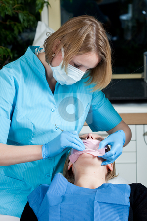 To use this stock image in your creative project, please select the size you need over to the right and click the "Add to Cart" button.
Your downloaded image will come with the Cutcaster watermark removed so don’t worry about the watermark you see on this page. Preparing for treatment stock photo, Female dentist preparing the mouth of her patient for treatment by Simone Van den Berg