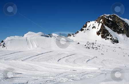 To use this stock image in your creative project, please select the size you need over to the right and click the "Add to Cart" button.
Your downloaded image will come with the Cutcaster watermark removed so don’t worry about the watermark you see on this page. Alpine ski slope and skiers stock photo, Scenic view of Alpine ski ski with skiers and mountain in background, Switzerland. by Martin Crowdy