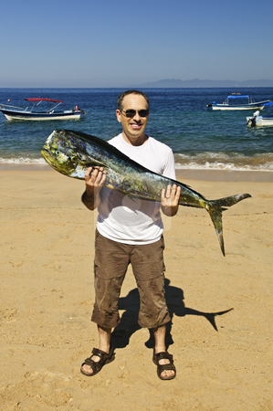 To use this stock image in your creative project, please select the size you need over to the right and click the "Add to Cart" button.
Your downloaded image will come with the Cutcaster watermark removed so don’t worry about the watermark you see on this page. Tourist holding big fish on beach stock photo, Happy tourist holding his big fish catch after fishing trip in Mexico by Elena Elisseeva