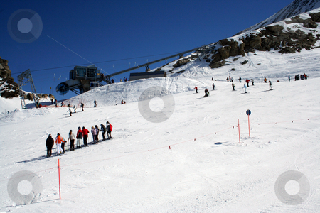 To use this stock image in your creative project, please select the size you need over to the right and click the "Add to Cart" button.
Your downloaded image will come with the Cutcaster watermark removed so don’t worry about the watermark you see on this page. Skiers on alpine ski slope stock photo, Group of skiers on snowy alpine ski slope, Switzerland. by Martin Crowdy