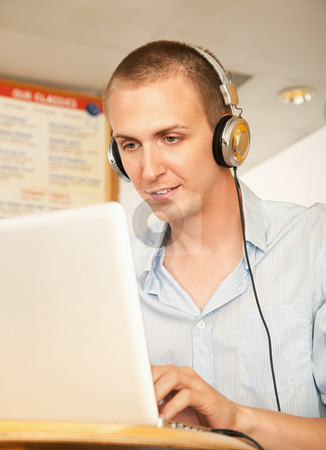 To use this stock image in your creative project, please select the size you need over to the right and click the "Add to Cart" button.
Your downloaded image will come with the Cutcaster watermark removed so don’t worry about the watermark you see on this page. Young Man with Laptop and Headphones stock photo, A young man using a laptop and listening to headphones. Vertical shot. by Scott Griessel