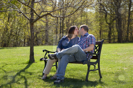 To use this stock image in your creative project, please select the size you need over to the right and click the "Add to Cart" button.
Your downloaded image will come with the Cutcaster watermark removed so don’t worry about the watermark you see on this page. Couple outdoors stock photo, Attractive Caucasian couple together at the park on a bench kissing. by Christy Thompson