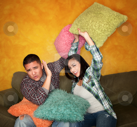 To use this stock image in your creative project, please select the size you need over to the right and click the "Add to Cart" button.
Your downloaded image will come with the Cutcaster watermark removed so don’t worry about the watermark you see on this page. Pillow Fight stock photo, Hispanic couple on couch play fighting with pillows by Scott Griessel